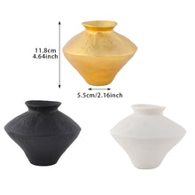 مزهرية معدنية باللون الذهبي والأبيض والأسود